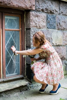 Woman in flowered dress knocking on window glass