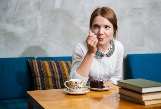 Woman eat cake with great pleasure  at cafe