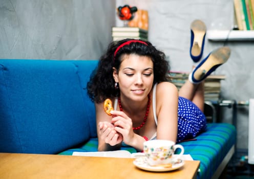 Woman lay on sofa and read funny book