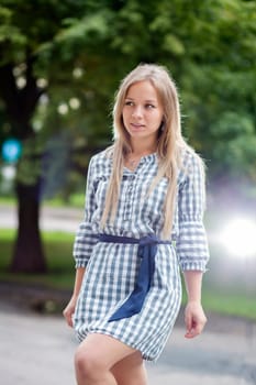 Woman in checkered dress walking in city park