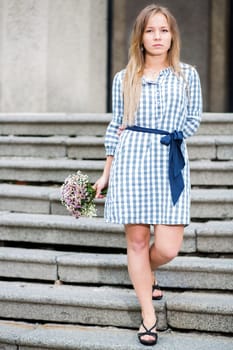 Woman in checkered dress at main enter stairs