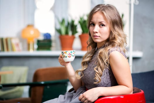 Woman hold cup and look directly at camera