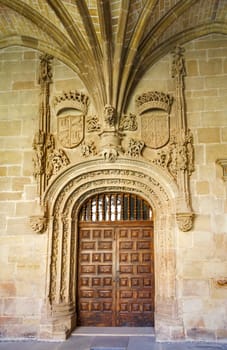 Cloister with prune in Santa Maria la Real monastery, Najera, La Rioja, Spain emblazoned door in the cloister