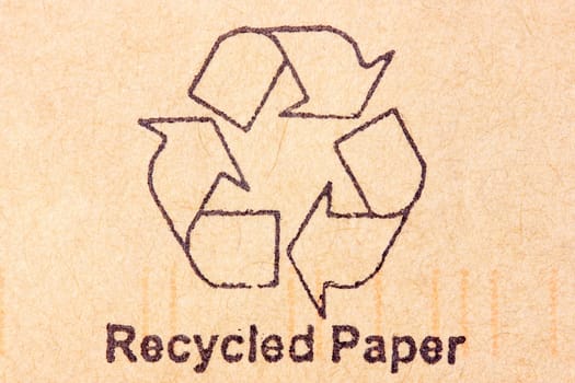 Brown recycled paper with black recycle symbol