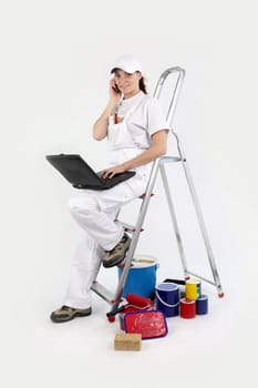craftswoman painter working on her laptop and talking on her cell