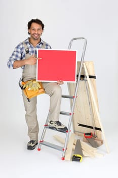 Male builder holding message board