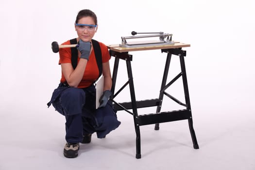 Woman kneeling beside her workbench