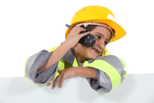 a little boy dressed in road man with a cell phone