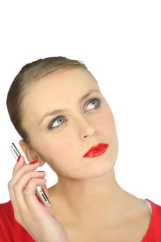 Blonde woman in red listening to a mobile phone
