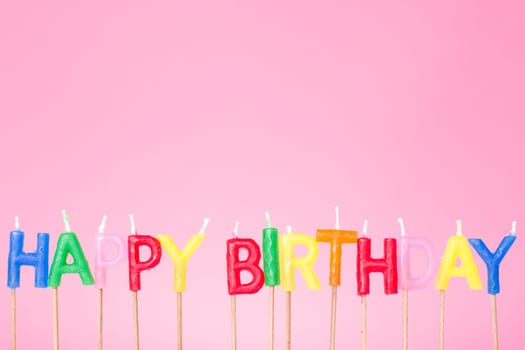 Colorful  Happy birthday candles on the  pink background