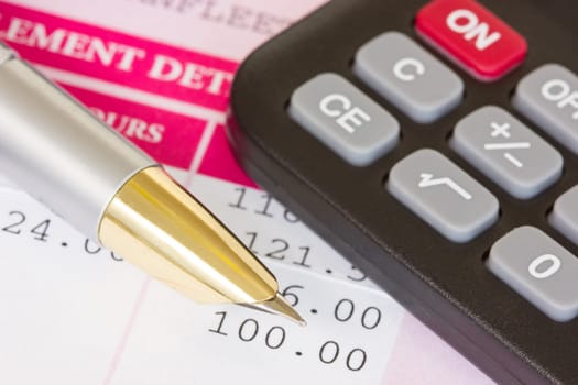 Metal pen, calculator and payslip with monthly wage