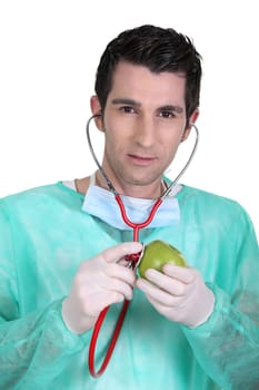 Doctor listening to an apple's heartbeat