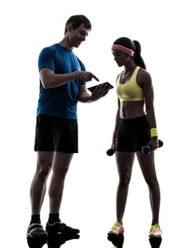 one  woman exercising fitness workout with man coach using digital tablet  in silhouette  on white background