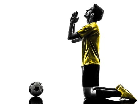 one brazilian soccer football player young man praying in silhouette studio  on white background