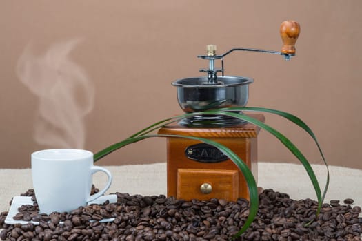 Still life about coffee with cups, beans and a mill