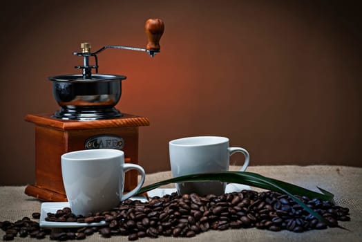 Still life about coffee with cups, beans and a mill