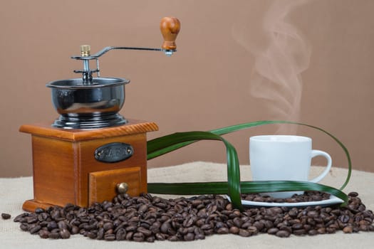 Still life about coffee with cups, beans and a mill