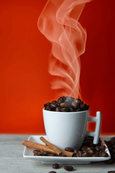 Cup full of coffee beans recently roasted and hot.