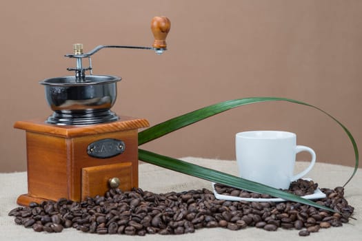 Still life about coffee with cups, beans and a mill