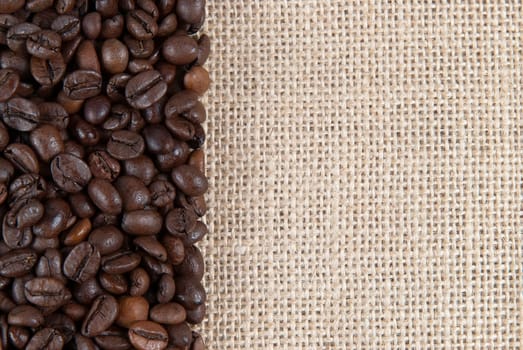 Background of burlap and coffee beans with a copy space.