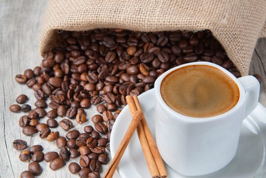 Still life about coffee with a delicious  espresso and some coffee beans and cinnamon.