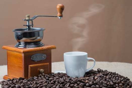 Still life about coffee with cups, beans and a mill