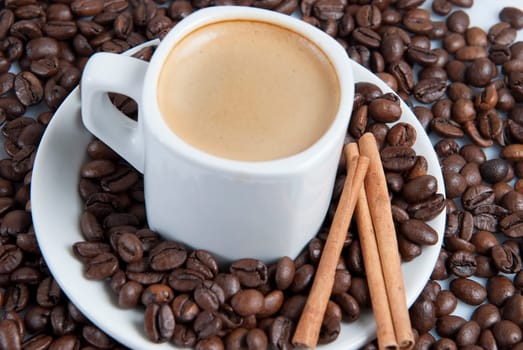 Still life about coffee with a delicious  espresso and some coffee beans and cinnamon.
