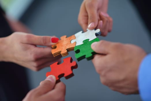 Group of business people assembling jigsaw puzzle and represent team support and help concept