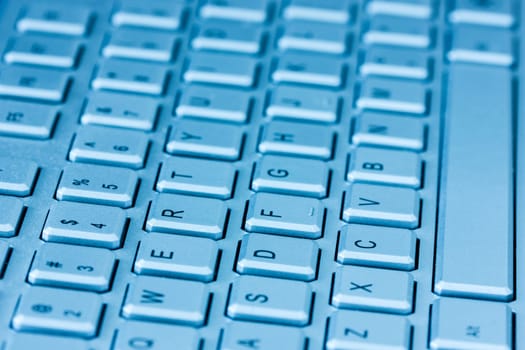 Computer keyboard in blue light. Small depth of field.