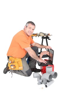 Plumber with a laptop and various tools of the trade
