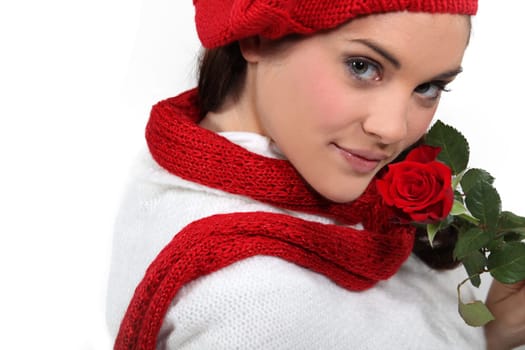 Brunette holding rose to face