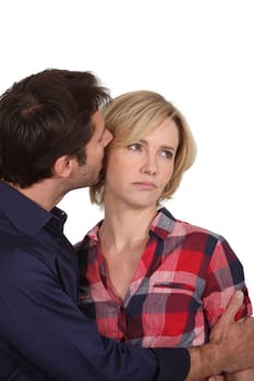 Man whispering in woman's ear
