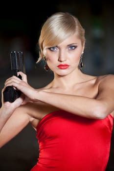 woman in retro look and red dress holding a handgun