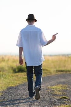 Young man walks in the field and is frustrated