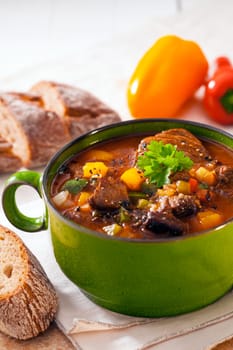 Nutritious winter casserole with meat and vegetables in a rich gravy served with slices of bread