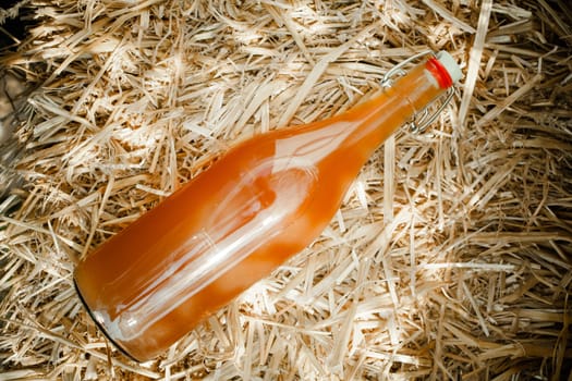 High angle close-up of a bottle of delicious natural homemade nectar on straw