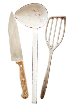 Three retro cooking utensils isolated n white with a sharp wooden handled chefs knife, metal ladle and metal spatula