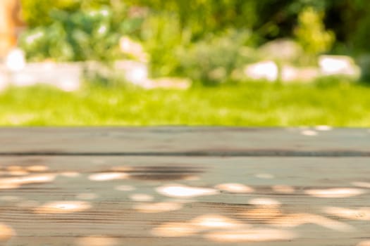 Close-up of a wooden table in the garden in a sunny day of summer