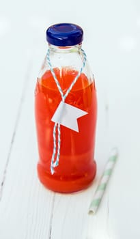 Close-up of a bottle of fresh tasty organic tomato juice with a blank label