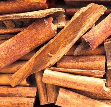 Close up background of dried stick cinnamon, a spice obtained from the inner bark of several trees from the genus Cinnamomum, used as a savoury spice and seasoning and flavouring in baking and cooking