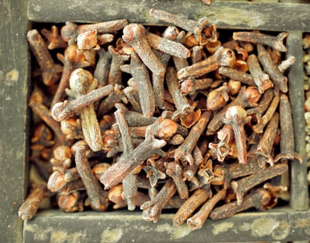 Overhead closeup view of dried cloves, the aromatic dried flower buds of a tree in the family Myrtaceae, used as a savoury seasoning and spice in cooking