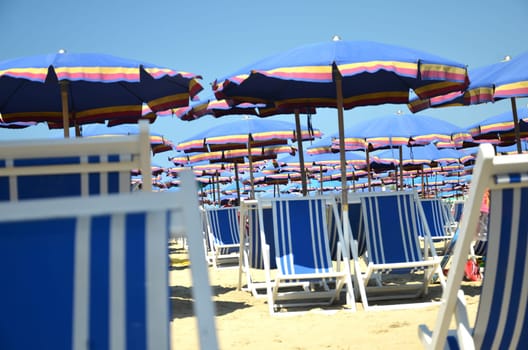Colorful beach umbrellas and chairs on beautiful beach in Marina di Pisa, Tuscany in Italy