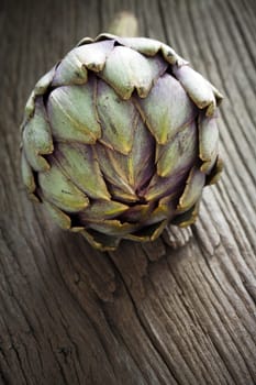 Artichoke on rustic wooden board