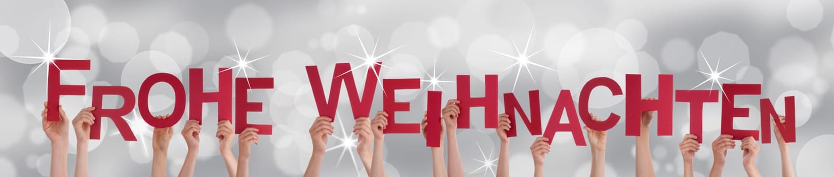 Many Hands Holding the German Words Frohe Weihnachten Which Means Merry Christmas on a Silver Background