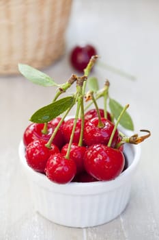 Bowl with cherries and a cherry in the background