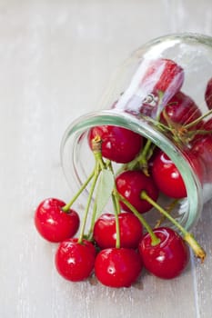 Red cherries in a lying mason jar
