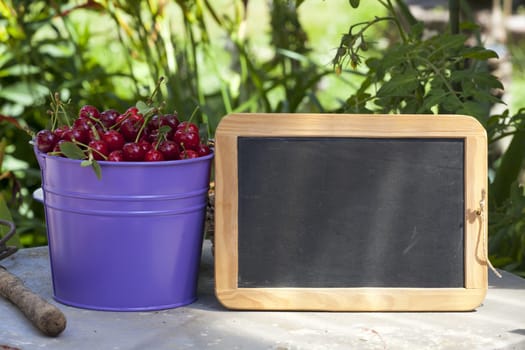 Buckets of cherries and a blank writable slate