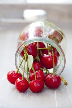 Glass filled with cherries lies on table