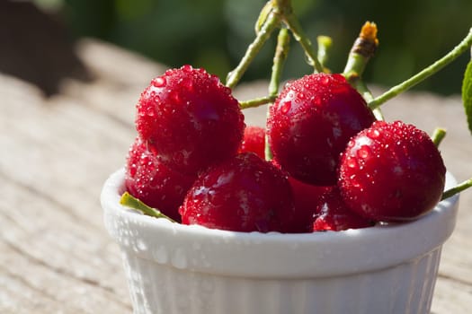 Cherries with stems in a white bowl