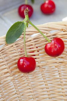 Two red cherries hang on the Korbrand